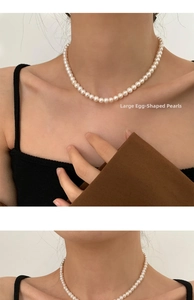 Detail of large oval freshwater pearl necklace worn on neck with 14K gold filled clasp