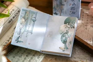 Close-up of A7 notebook with traditional Chinese ink paintings and elegant calligraphy