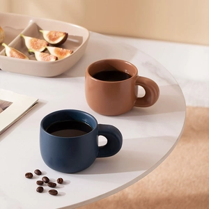 Minimalist matte ceramic coffee mugs with thick round handles in brown and navy blue colors