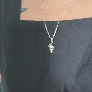 Dettaglio ravvicinato di una collana con ciondolo a conchiglia in argento sterling 925