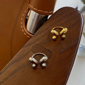 Minimalist butterfly open ring in polished gold and silver finish on wooden surface