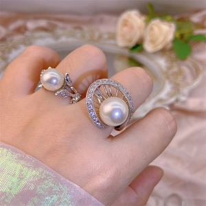 Exquisite pearl rings with silver finish and zircon stones shown on pink silk background
