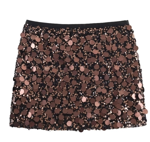 Detailed view of dense bronze sequins on a high-waisted mini skirt over white background
