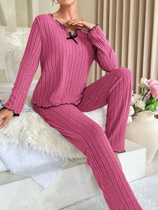 Detail of ribbed pajama fabric with black lettuce trim and bow tie in rose pink