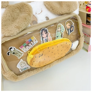 Detailed view of plush storage bag featuring a clear PVC window and fish-shaped pocket