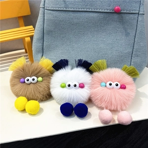 Detailed trio of colorful plush monster keychains in brown, white, and pink finishes