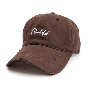 Close-up of distressed brim and New York embroidery on dark brown baseball cap