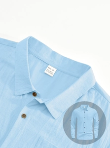 Detail of light blue linen shirt collar showing textured fabric and retro button finish