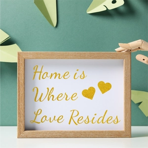 Detail of wooden picture frame with glittery gold lettering and minimalist wall art decor