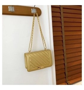 Detailed close-up of champagne gold chevron quilted bag with metal chain and turn-lock