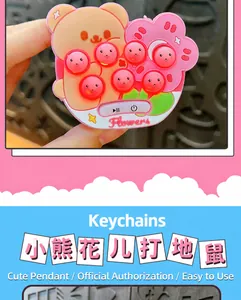 Close-up of a pink bear-shaped mini whack-a-mole electronic pop-it game keychain.