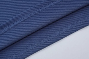 Gros plan sur le tissu en maille côtelée bleue montrant les coutures et la texture