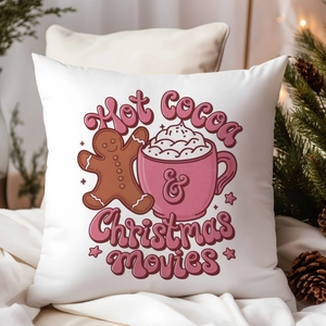 Detail of Christmas pillow cover with gingerbread and hot cocoa on cozy white bedding