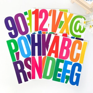 Close-up of 5-inch colorful vinyl letter and number stickers on white wood texture