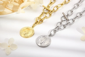 Close-up of gold and silver chain necklaces with religious coin pendants and T-bar toggle clasp