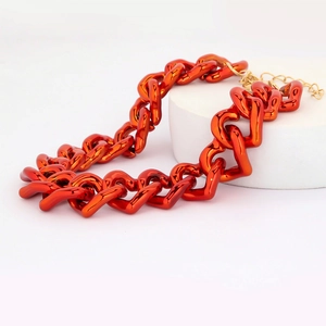 Close-up of vibrant red heart-shaped thick chain necklace with high-gloss metallic finish