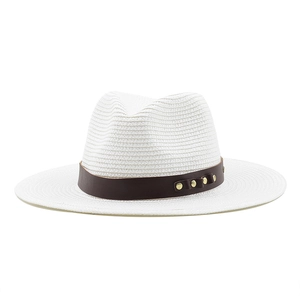 Détail d'un chapeau fedora blanc avec ruban en cuir marron et clous dorés