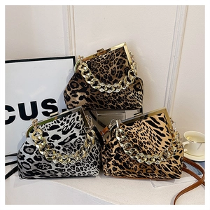 Close-up of three leopard print shell bags with gold chain handles and metal frames