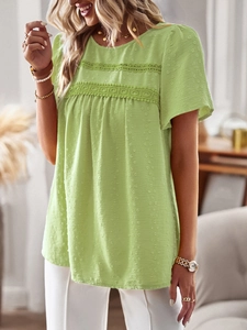 Detail showing light green round neck top with polka dot texture and lace stitching
