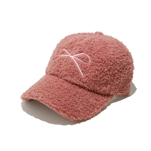 Detailed macro view of the soft pink teddy fleece texture and bow embroidery on baseball cap
