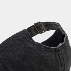 Detail of vintage bronze metal adjustable buckle on washed cotton baseball cap
