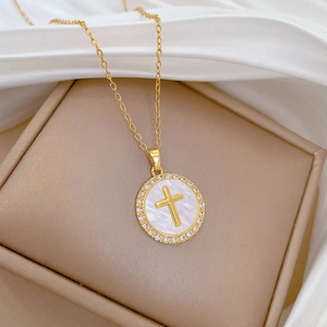 Detailed macro of gold cross pendant with mother-of-pearl and sparkling zircon stones