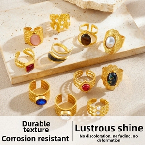 Close-up of 10-piece gold-plated ring set with pearls and gemstones on stone display