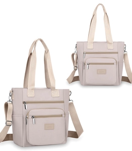 Detail view of large beige oxford cloth shoulder bag with multiple zippered pockets