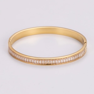 Macro view of gold stainless steel bangle with rectangular zirconia insets