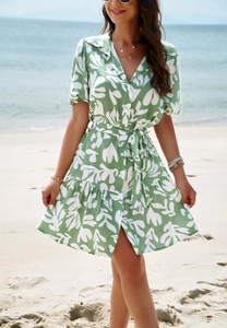 Detail view of V-neckline with buttons and leaf print on the green summer dress