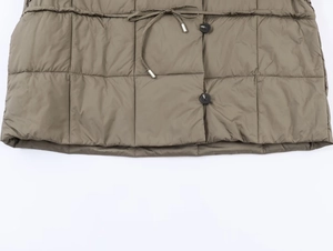 Detail of olive green quilted jacket featuring a drawstring waist and black round buttons
