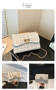 Detailed view of the white tweed plaid pattern with golden stitching and metal chain strap