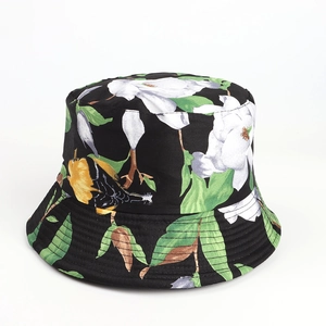 Close-up of black bucket hat featuring white magnolia floral and bird print patterns