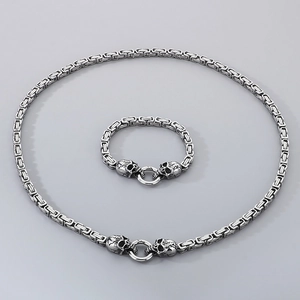 Detailed view of punk skull clasps on silver stainless steel cuban chain set