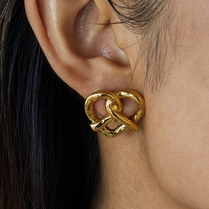 Boucles d'oreilles nœud cœur en acier inoxydable plaqué or 18K sur un mannequin