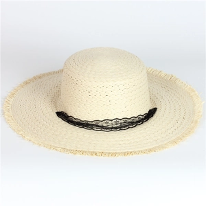 Detailed macro view of straw hat featuring black floral lace trim and frayed raw edges