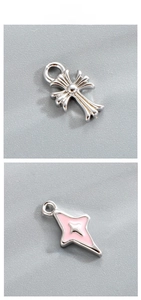 Macro detail of silver cross pendant and pink enamel star for DIY jewelry design