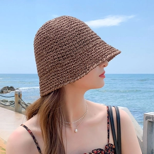 Women's brown hand-woven straw bucket hat with sun protection for seaside beach vacation