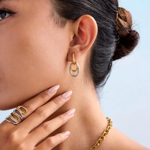 Détail de bagues, boucles d'oreilles et collier en or et argent bicolore entrelacés