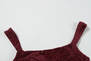 Detail of wine red dress featuring square neckline and textured 3D floral rose patterns