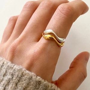Minimalist 925 sterling silver dual-tone gold and silver wave ring worn on finger