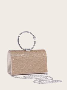 Detail of evening clutch with gold rhinestones, silver circular handle and metal chain