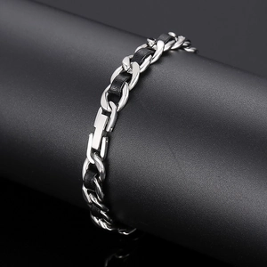 Détail du bracelet gourmette en acier inoxydable entrelacé de cuir tressé noir