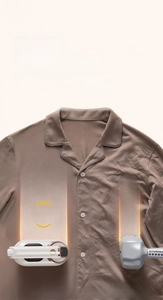 Detail view of portable garment steamer showing ironing results on a brown shirt