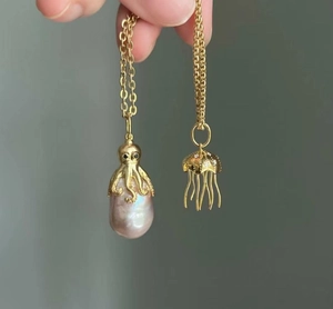 Detailed close-up of golden octopus and jellyfish pendants with baroque pearls
