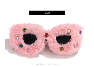 Close-up of pink fluffy sunglasses with colorful rhinestone accents and dark lenses