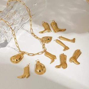 Gold chain necklace with sparkling cowboy boot and hat pendants on white background