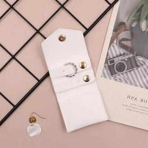 Close-up of white PU leather jewelry organizer with gold buckle and inner ring slots