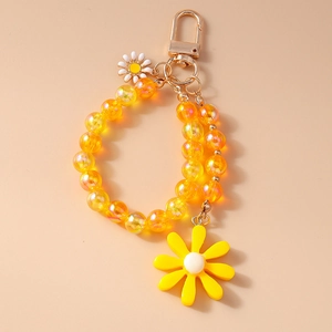 Close-up of yellow beaded strawberry daisy flower keychain with golden metal clasp