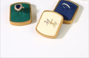 Close-up of luxury 4-slot ring display stands with gold frames in green and beige